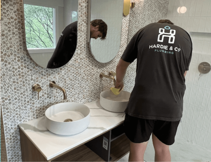 manly plumber fixing a leaking tap